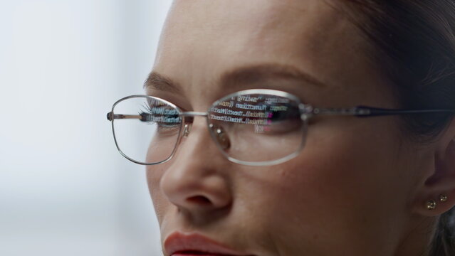Developer glasses reflecting code lines closeup. Woman hacker programming app