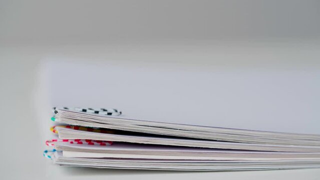 Time lapse studio shot of paper sheets. Stop motion animation of business or educational paper documents with paper clips decreasing.