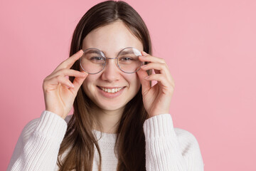 girl in round glasses on a pink background