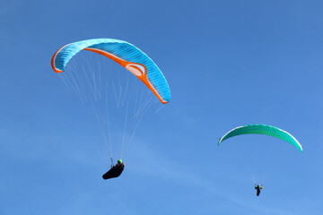 Paragliders flying in a blue sky	