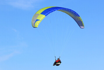 Paraglider flying in a blue sky	