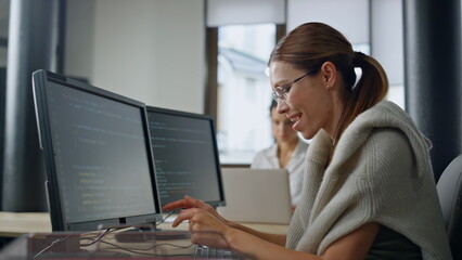 Smiling it woman programming software in office. Startup engineer checking code