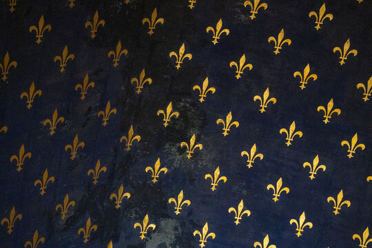 Repeating vintage fleur de lis (lily flower) golden pattern on blue background