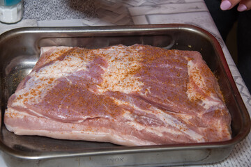 Pork belly steak seasoned with thyme, red onion, garlic and tomato sauce, stages of preparation