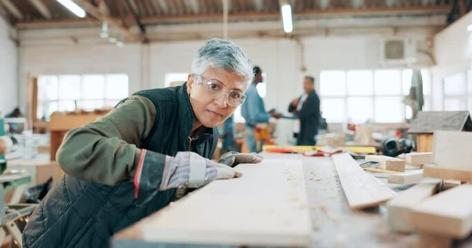 Woman, woodwork and sanding with sawdust in workshop or craft for furniture, small business or manufacturing. Mature person, hand and protection glasses or timber plank for diy, hobby or carpentry