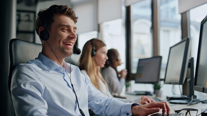 Smiling telemarketing agent talking in office. Friendly professional team help