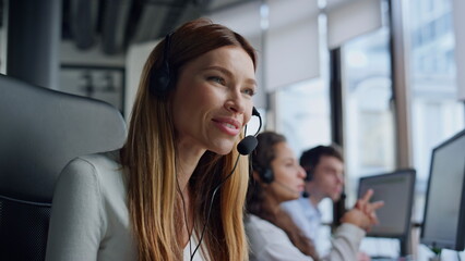 Friendly woman work telemarketing center. Helpful sales manager talking headset - obrazy, fototapety, plakaty