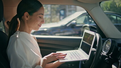 Smart lady boss car looking laptop sitting at front seat closeup. Woman working