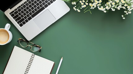 Desk office with laptop, blank notebook, flower, coffee cup, glasses and pen on green table. Flat lay top view copy space. Home office. - obrazy, fototapety, plakaty