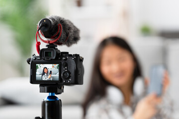 Focus on the screen of a camera while a streamer recording an online tutorial at home