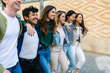 Diverse group of friends walking together in the city. Millennial student people hanging out...