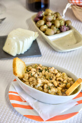 Delicious array of Portuguese starters: fresh bread, mild cheese, tempting olives, and tuna with black-eyed peas, perfect for any restaurant.