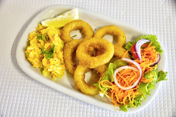 Delicious breaded squid rings served with rice and fresh salad. An irresistible combination of flavors and textures.