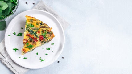 Piece of brunch egg frittata with vegetables on plate, horizontal, top view, copy space