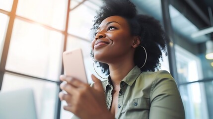 African black business woman using smartphone while working on laptop at office. Smiling mature african american businesswoman looking up while working on phone. Successful woman entre : Generative AI
