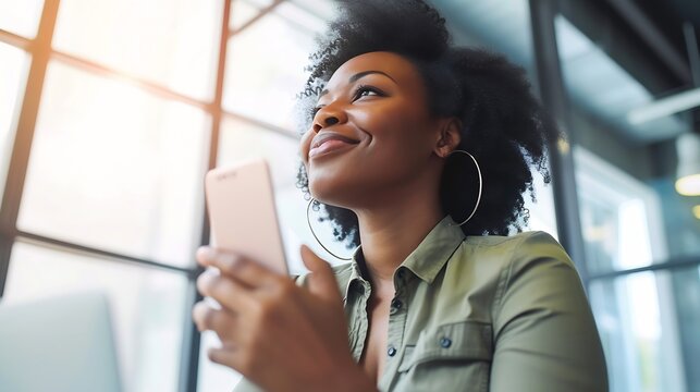 African black business woman using smartphone while working on laptop at office. Smiling mature african american businesswoman looking up while working on phone. Successful woman entre : Generative AI