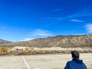 Pilots Flying Radio a Controlled Model Plane Aircraft at a Club Field looking at a Pilot Flying a...