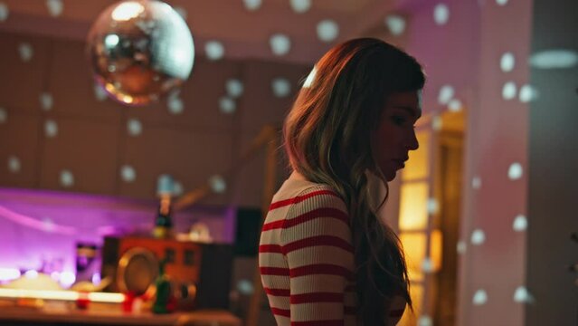 Sad girl standing alone in party room after hangout close up. Unhappy woman