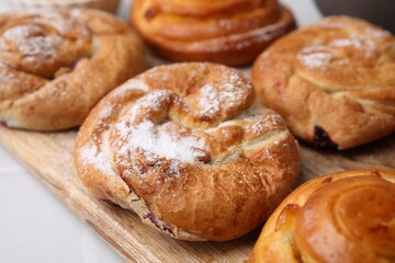 Obraz na płótnie Canvas Delicious rolls with powdered sugar on table, closeup. Sweet buns