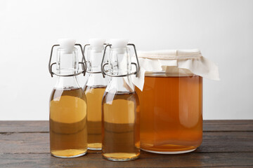 Homemade fermented kombucha in glass jar and bottles on wooden table