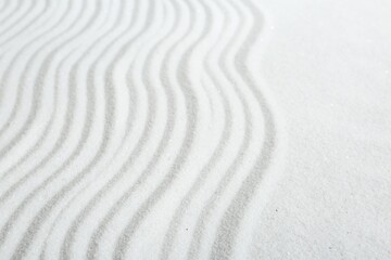 Zen rock garden. Wave pattern on white sand, closeup