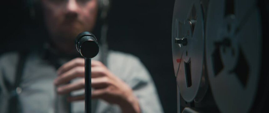 An intelligence officer listening to the recording with the attention and then rewinds the tape