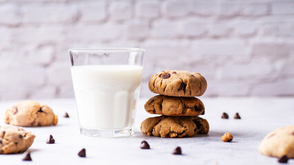Chocolate chip cookies and a glass of milk on a light background