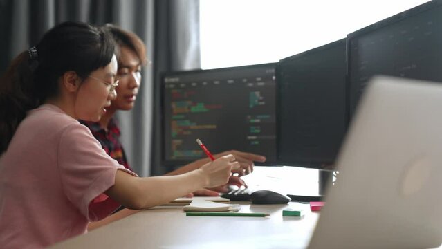 Back end software developer engineer for computer programming working together on debugging writing computing code, solving complex algorithms display on monitor in office. Burgeoning