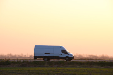 Small cargo van driving on highway hauling goods. Delivery transportation and logistics concept