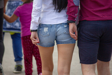 Sexy ass in cute jeans style, slim ass in pants. Sexy woman's body in denim shorts. man from behind...