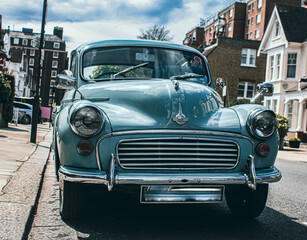 a vintage car stands on the street during beautiful sunny weather, 
oldtimer
