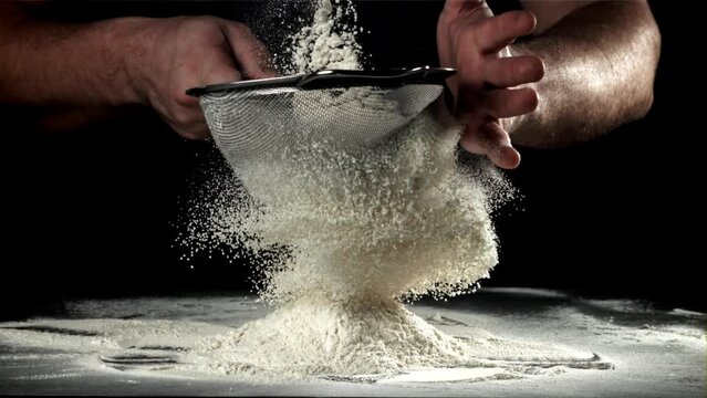 The cook sifts the flour. Filmed on a high-speed camera at 1000 fps. High quality FullHD footage