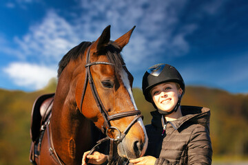 Obraz premium Horse head portraits in front of a blue sky and a rider standing next to it..