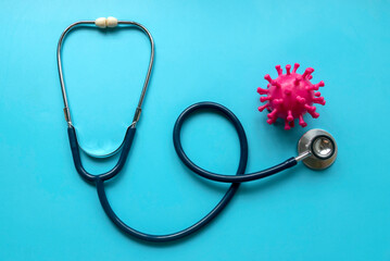 Virus model and stethoscope over a blue background.