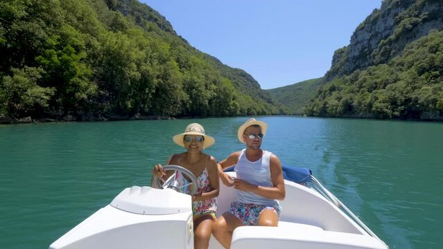 A couple of men and women in an electric boat at Gorges Du Verdon Lake River in France Provence, lake of Sainte Croix Provence Alpes Cote d Azur, 