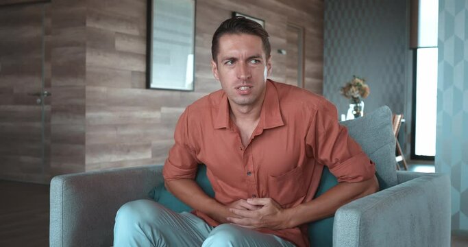 Man chair clutches his stomach, feeling nauseous, discomfort. acute sensation pain, state well-being. sudden nature physical ailments, recognizing addressing health issues alleviate pain discomfort.