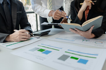 Mixed group of business people sitting around a table and working, Business team working on a project in the office around a table or reviewing and discussing a business project.