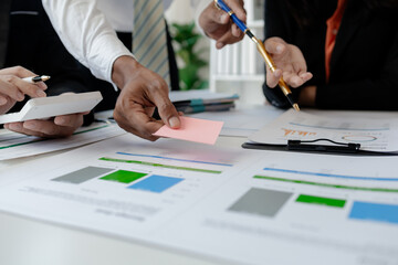group of employees is discussing the details of an upcoming event, close-up view of the meeting situation, Business men and women are having a tense meeting in a translucent conference room.
