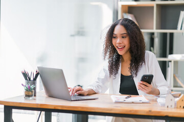 Smiling African American Businesswoman Using Smartphone at Work.