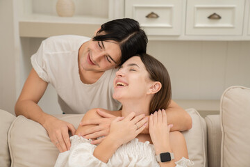 A young man putting the necklace around his girlfriend's neck in the kitchen on Valentine's Day Valentine's Day concept. Lovers at home celebrating Valentine's Day