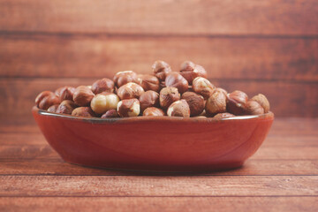 hazelnuts in a container on black background,