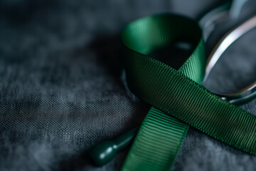 Green ribbon symbol for world bipolar day on blurred background