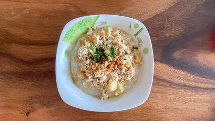 top view of rice porridge with pork and egg or congee is similar to boil rice but it has softer texture is on the wooden table for breakfast in the moring