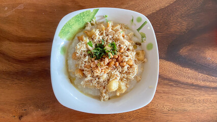top view of rice porridge with pork and egg or congee is similar to boil rice but it has softer texture is on the wooden table for breakfast in the moring