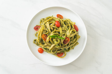 fettuccine spaghetti pasta with pesto sauce and tomatoes