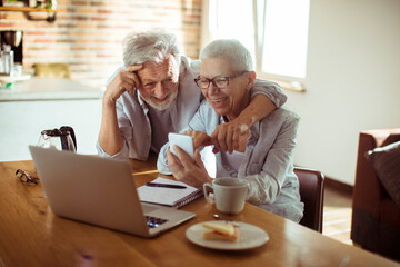 Senior couple using a phone at home