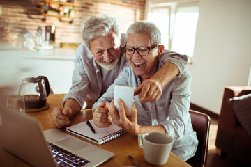 Senior couple using a phone at home