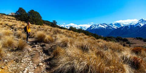 hiker girl walking on a bealey spur track in arthur's pass national park, canterbury, new zealand;...