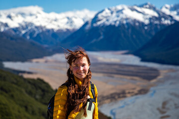 pretty hiker girl admiring the panorama of waimakariri river valley and snow capped mountains in...