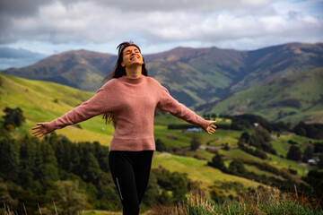 pretty hiker girl enjoys the idyllic landscape of banks peninsula near akaroa, canterbury, new zealand